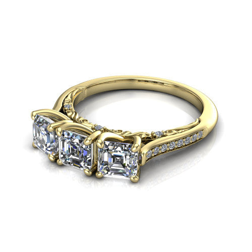 Emory square emerald-cut three-stone engagement ring in 14K Yellow Gold, three-quarter perspective showing the three matched square emerald-cut diamonds, pave-set band, and filigree under-gallery