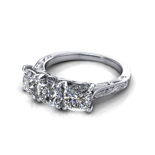 Navy cushion three stone engagement ring in 18K White Gold, three-quarter perspective showing three cushion diamonds above an engraved filigree band