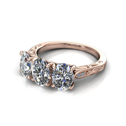 Navy oval three stone engagement ring in 14K Rose Gold, three-quarter perspective showing three oval diamonds above an engraved filigree band