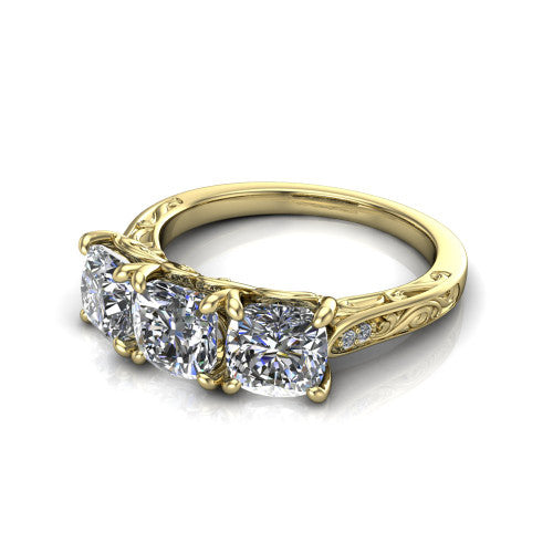 Navy cushion three stone engagement ring in 18K Yellow Gold, three-quarter perspective showing three cushion diamonds above an engraved filigree band