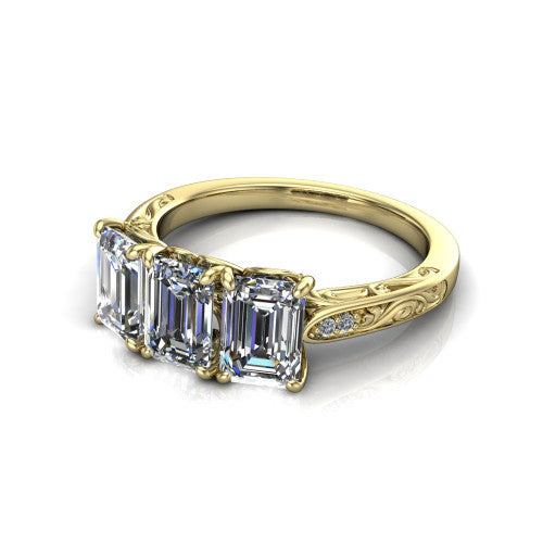 Navy emerald three stone engagement ring in 18K Yellow Gold, three-quarter perspective showing three emerald diamonds above an engraved filigree band
