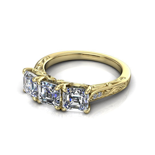 Navy square emerald three stone engagement ring in 14K Yellow Gold, three-quarter perspective showing three square emerald diamonds above an engraved filigree band