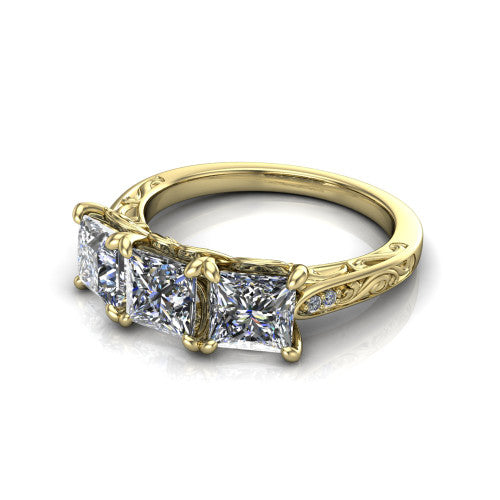 Navy princess three stone engagement ring in 18K Yellow Gold, three-quarter perspective showing three princess diamonds above an engraved filigree band