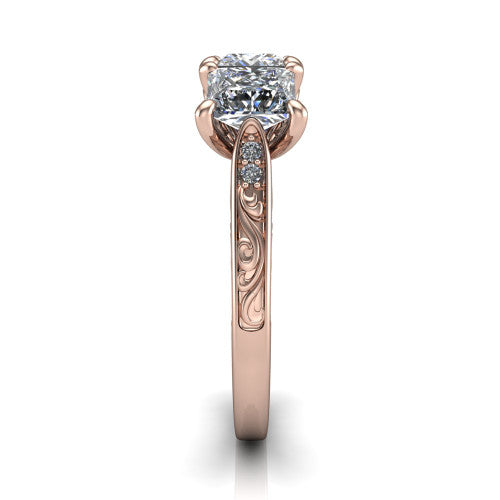 Navy princess three stone engagement ring in 18K Rose Gold, side profile showing the vintage engraved filigree band and the raised three-stone setting