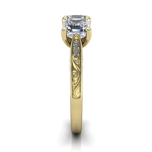 Navy square emerald three stone engagement ring in 14K Yellow Gold, side profile showing the vintage engraved filigree band and the raised three-stone setting