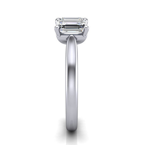 Amora emerald three stone engagement ring in 18K White Gold, side profile showing the plain polished band and the raised three-stone setting