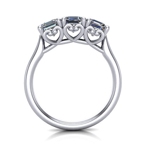 Amora square emerald three stone engagement ring in 14K White Gold, through-finger side profile showing the heart filigree scroll gallery beneath the three stones