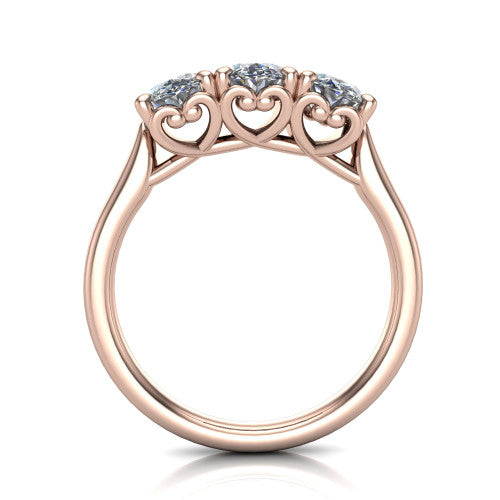 Amora oval three stone engagement ring in 18K Rose Gold, through-finger side profile showing the heart filigree scroll gallery beneath the three stones