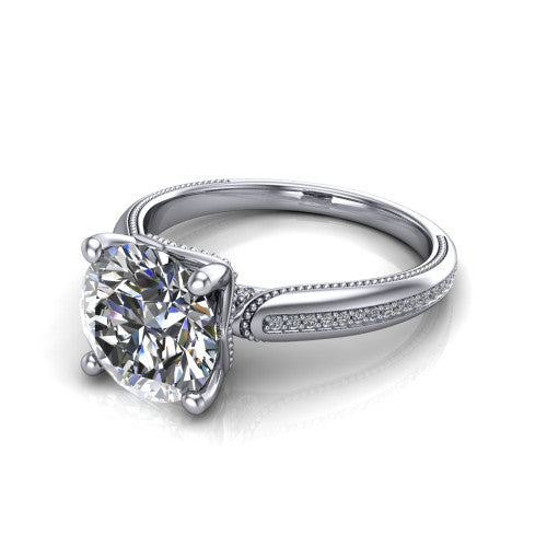 Vanessa round solitaire engagement ring in 18K White Gold, three-quarter perspective showing the prong-set center raised above a slim pav&eacute; milgrain band