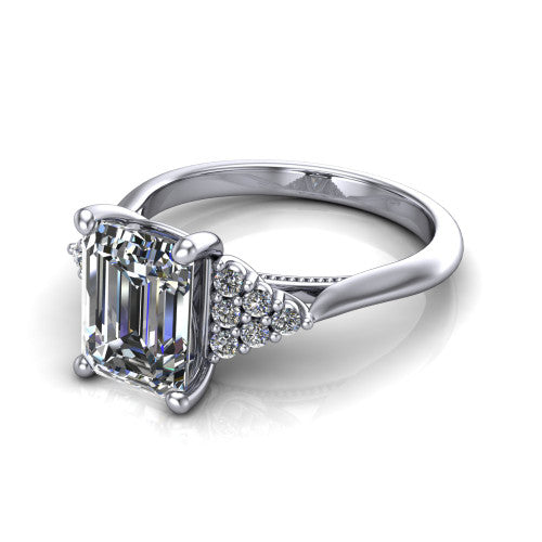 Raya emerald three stone engagement ring in 14K White Gold, three-quarter perspective showing the center stone flanked by a trio diamond cluster on each shoulder above a slim milgrain band