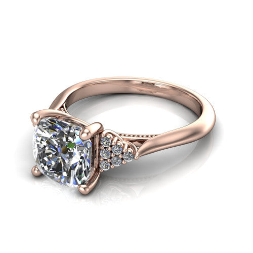 Raya cushion three stone engagement ring in 14K Rose Gold, three-quarter perspective showing the center stone flanked by a trio diamond cluster on each shoulder above a slim milgrain band