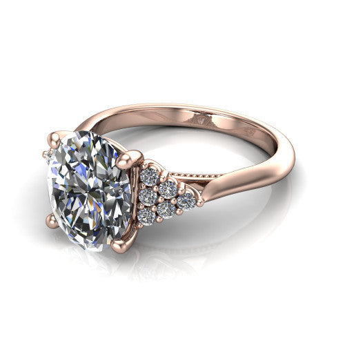 Raya oval three stone engagement ring in 14K Rose Gold, three-quarter perspective showing the center stone flanked by a trio diamond cluster on each shoulder above a slim milgrain band