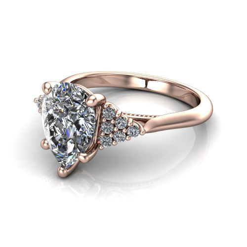 Raya pear three stone engagement ring in 14K Rose Gold, three-quarter perspective showing the center stone flanked by a trio diamond cluster on each shoulder above a slim milgrain band