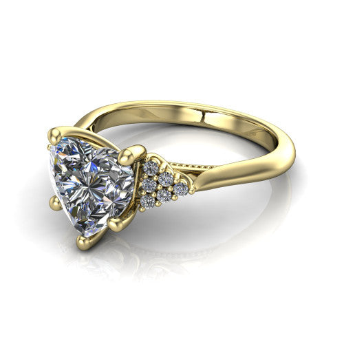 Raya heart three stone engagement ring in 18K Yellow Gold, three-quarter perspective showing the center stone flanked by a trio diamond cluster on each shoulder above a slim milgrain band