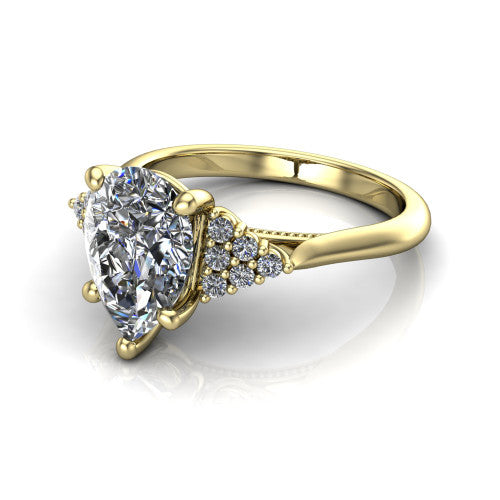 Raya pear three stone engagement ring in 18K Yellow Gold, three-quarter perspective showing the center stone flanked by a trio diamond cluster on each shoulder above a slim milgrain band