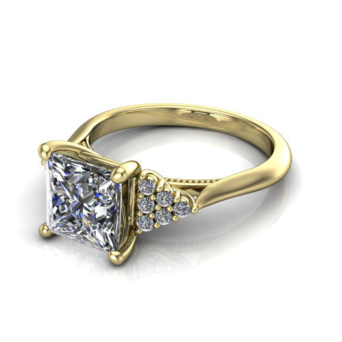 Raya princess three stone engagement ring in 18K Yellow Gold, three-quarter perspective showing the center stone flanked by a trio diamond cluster on each shoulder above a slim milgrain band