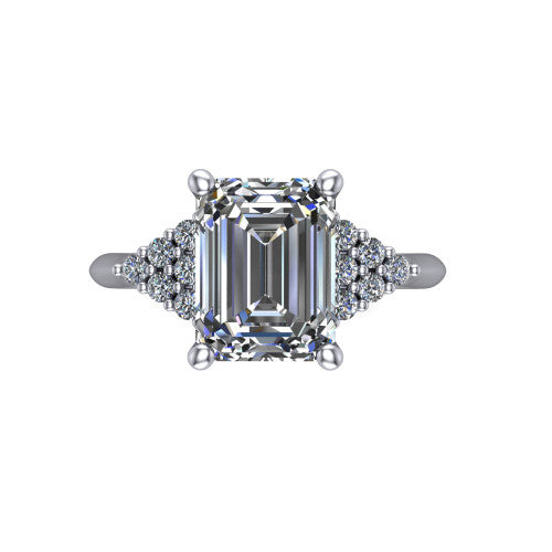 Raya emerald three stone engagement ring in 14K White Gold, top-down view showing the round center with graduated three-stone clusters to each side from above
