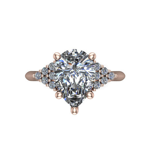 Raya pear three stone engagement ring in 14K Rose Gold, top-down view showing the round center with graduated three-stone clusters to each side from above
