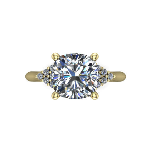 Raya cushion three stone engagement ring in 18K Yellow Gold, top-down view showing the round center with graduated three-stone clusters to each side from above
