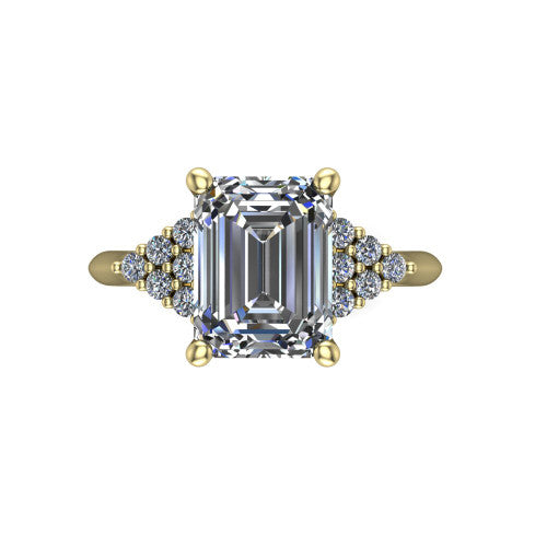 Raya emerald three stone engagement ring in 18K Yellow Gold, top-down view showing the round center with graduated three-stone clusters to each side from above