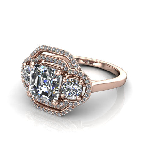 Elle square emerald three stone halo engagement ring in 14K Rose Gold, three-quarter perspective showing the center stone flanked by two side stones in an interlocking double pav&eacute; halo above a tapered band