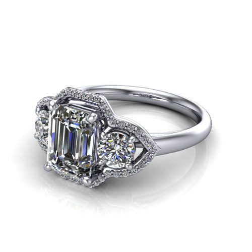 Kalani emerald halo engagement ring in Platinum, three-quarter perspective showing the haloed center and two haloed round side stones linked by open scroll bridges