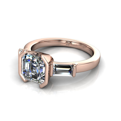 Amanda asscher three stone engagement ring in 18K Rose Gold, three-quarter perspective showing the center diamond between two tapered baguette side stones on a slim polished band