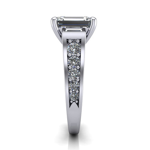 Estella emerald three stone engagement ring in Platinum, side profile showing the tapered baguette side stone and the round diamonds running down the shank