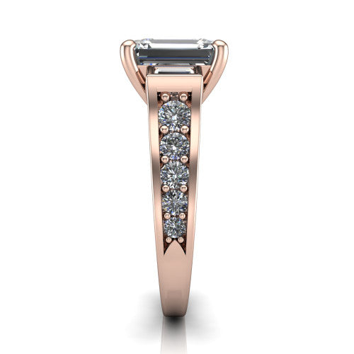 Estella emerald three stone engagement ring in 14K Rose Gold, side profile showing the tapered baguette side stone and the round diamonds running down the shank