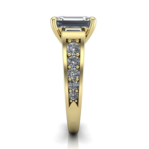Estella emerald three stone engagement ring in 18K Yellow Gold, side profile showing the tapered baguette side stone and the round diamonds running down the shank