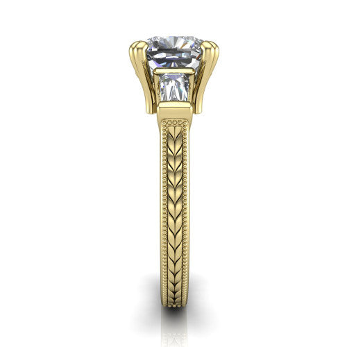 Camille cushion three stone engagement ring in 18K Yellow Gold, side profile showing the tapered baguette side stone and the hand-engraved wheat pattern down the band