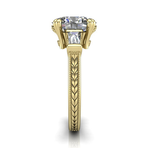 Camille oval three stone engagement ring in 14K Yellow Gold, side profile showing the tapered baguette side stone and the hand-engraved wheat pattern down the band