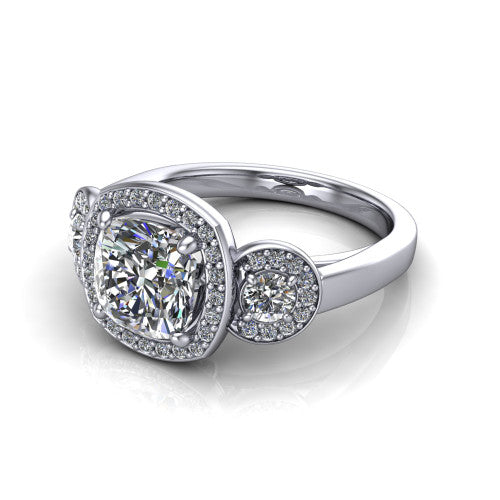 Wrenley cushion three stone engagement ring in Platinum, three-quarter perspective showing the haloed center between two haloed round side stones on a polished band