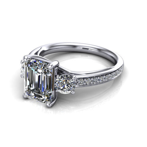 London emerald classic engagement ring in Platinum, three-quarter perspective showing the center diamond between two round side stones above a pav&eacute; shank