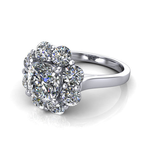 Gabriela cushion halo engagement ring in Platinum, three-quarter perspective showing the center framed by a cluster halo of round diamonds above a slim polished band