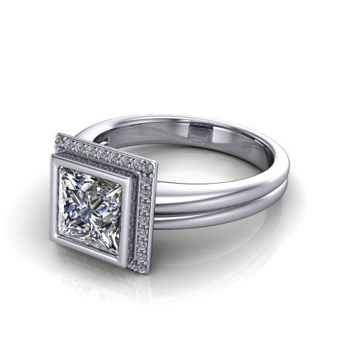 Maggie princess halo engagement ring in 18K White Gold, three-quarter perspective showing the bezel-set center framed by a pav&eacute; halo on a polished double-rail shank
