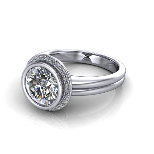 Maggie round halo engagement ring in Platinum, three-quarter perspective showing the bezel-set center framed by a pav&eacute; halo on a polished double-rail shank