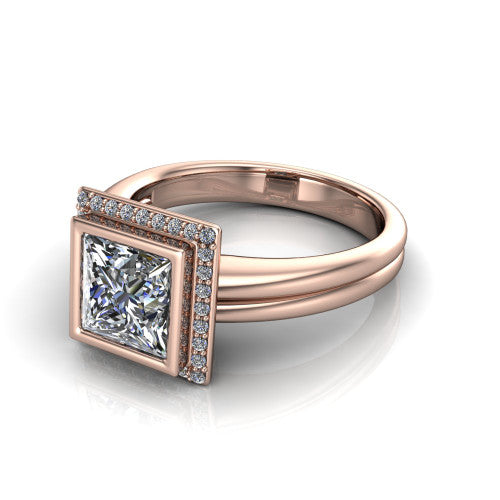Maggie princess halo engagement ring in 18K Rose Gold, three-quarter perspective showing the bezel-set center framed by a pav&eacute; halo on a polished double-rail shank