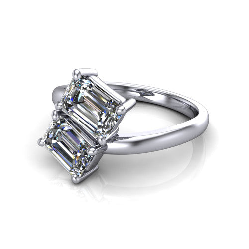 Adelaide emerald three stone engagement ring in Platinum, three-quarter perspective showing two diamonds set corner to corner on a slim polished bypass band