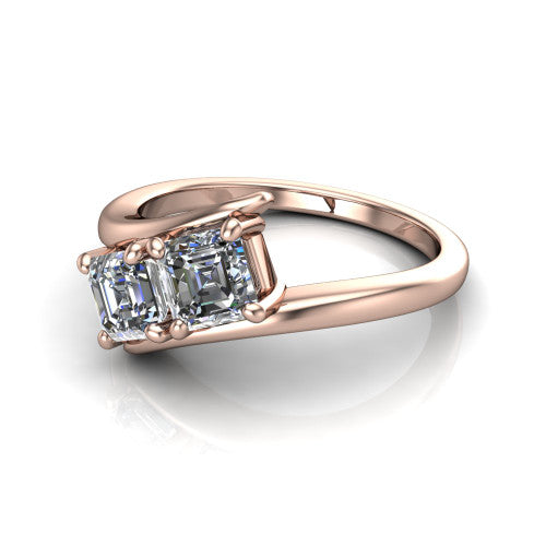 Alayna asscher three stone engagement ring in 18K Rose Gold, three-quarter perspective showing two diamonds set diagonally in claw baskets on a polished bypass swirl shank
