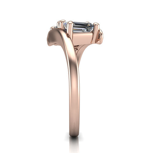 Alayna emerald three stone engagement ring in 14K Rose Gold, side profile showing the bypass swirl shoulders crossing beneath the two-stone head