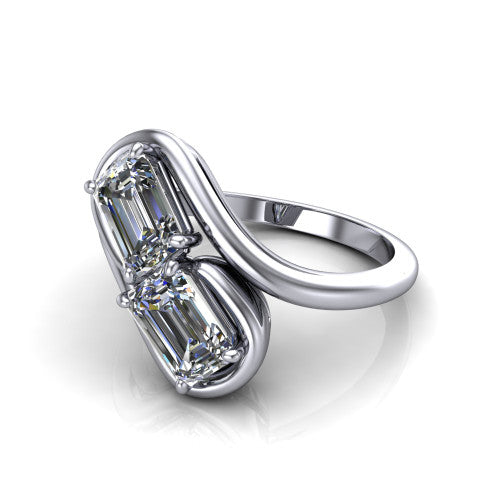 Daniela emerald three stone engagement ring in Platinum, three-quarter perspective showing two emerald cut diamonds half-bezel set diagonally on a polished bypass shank