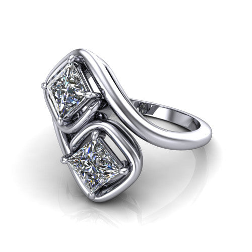 Daniela princess three stone engagement ring in 18K White Gold, three-quarter perspective showing two princess cut diamonds half-bezel set diagonally on a polished bypass shank
