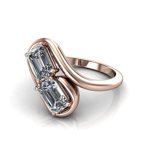 Daniela emerald three stone engagement ring in 18K Rose Gold, three-quarter perspective showing two emerald cut diamonds half-bezel set diagonally on a polished bypass shank