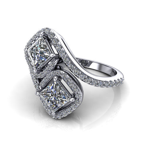 Jane princess three stone engagement ring in Platinum, three-quarter perspective showing two princess cut diamonds set diagonally in twin square halos on a pave wraparound shank with bypass swirling shoulders