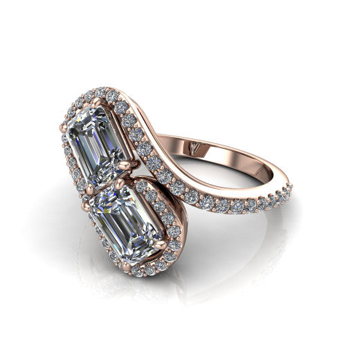 Jane emerald three stone engagement ring in 18K Rose Gold, three-quarter perspective showing two emerald cut diamonds set diagonally in twin square halos on a pave wraparound shank with bypass swirling shoulders