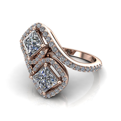 Jane princess three stone engagement ring in 18K Rose Gold, three-quarter perspective showing two princess cut diamonds set diagonally in twin square halos on a pave wraparound shank with bypass swirling shoulders