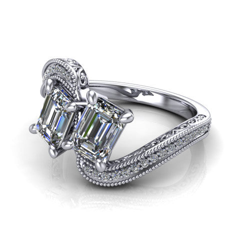 Stevie emerald three stone engagement ring in 14K White Gold, three-quarter perspective showing two step-cut emerald diamonds set diagonally on filigree shoulders with milgrain edges and a pave center band