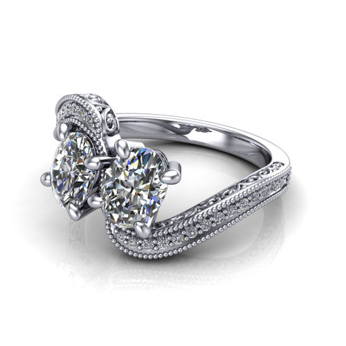 Stevie oval three stone engagement ring in Platinum, three-quarter perspective showing two brilliant oval diamonds set diagonally on filigree shoulders with milgrain edges and a pave center band