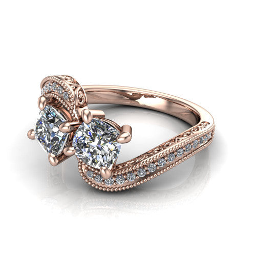 Stevie cushion three stone engagement ring in 14K Rose Gold, three-quarter perspective showing two brilliant cushion-cut diamonds set diagonally on filigree shoulders with milgrain edges and a pave center band